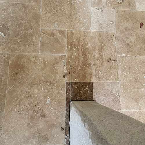 Wand und Boden mit Travertin-Natursteinplatten im Rohbauzustand